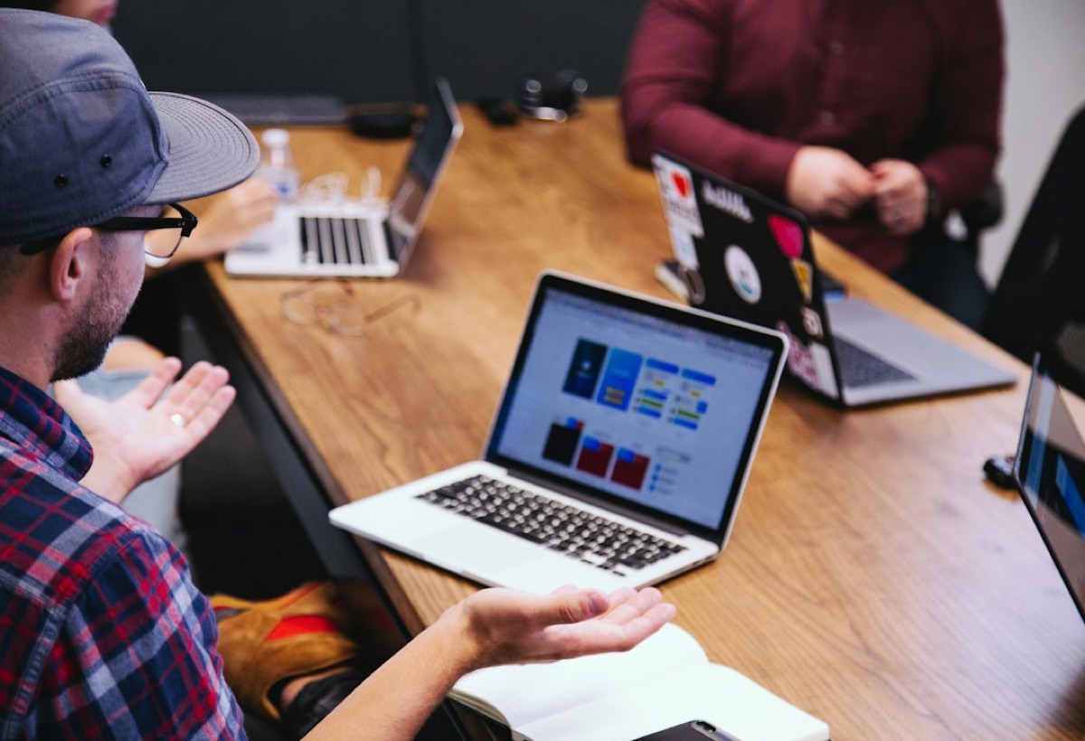 Colleagues discussing a project around laptops